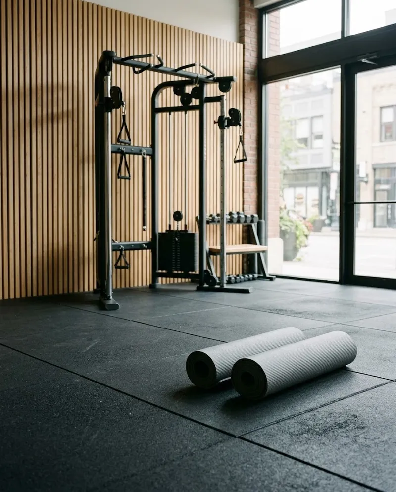 A zona de treino com tapetes e uma máquina de cabos